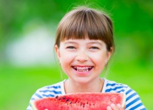 Girl with braces eating watermelon