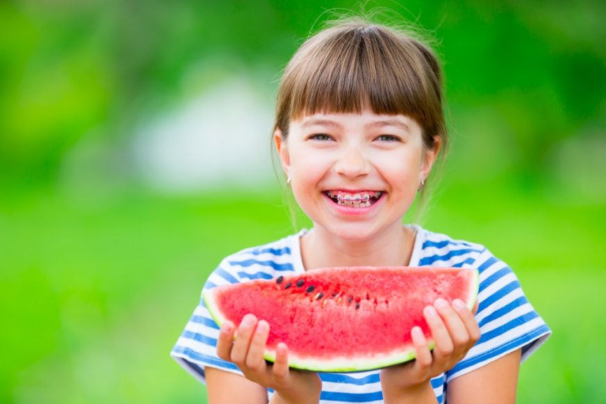 Girl with braces eating watermelon