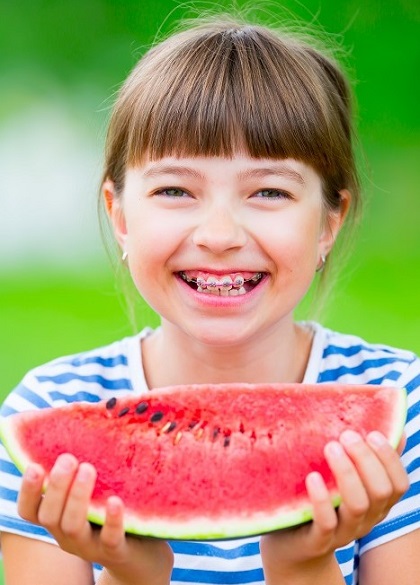 Girl with braces eating watermelon