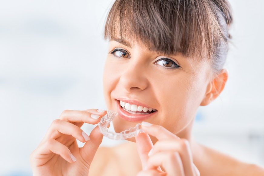 Woman Putting in Clear Aligners